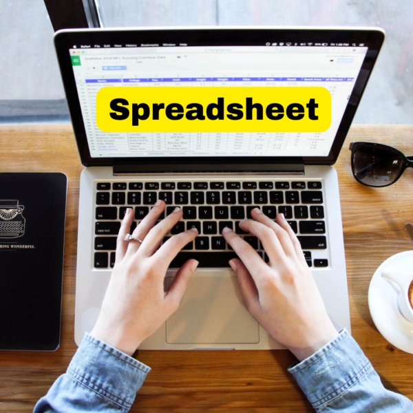 Hands creating a spreadsheet on a laptop computer. Screen has a yellow banner with the word Spreadsheet on it.